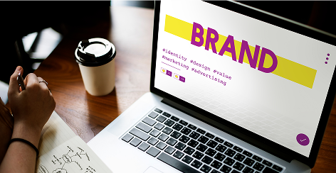 Laptop showing a brand identity slide beside a coffee cup