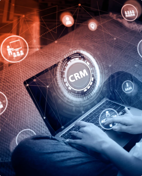 Person typing on a laptop beneath a glowing CRM network graphic