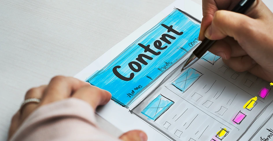 A hand sketching a content page wireframe