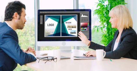 Two designers reviewing a logo concept on screen